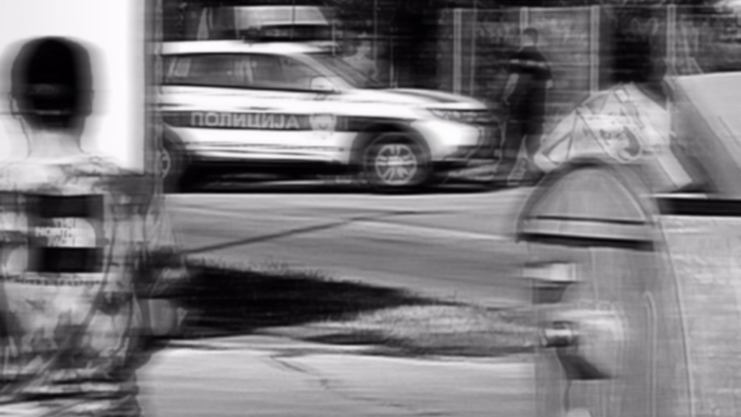 Black and white street scene with a car and people, featuring a 'Parental Advisory Explicit Content' label.